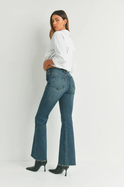 Woman in HR SCISSOR CUT FLARE DENIM, stylish black heels, women’s boho chic clothing
