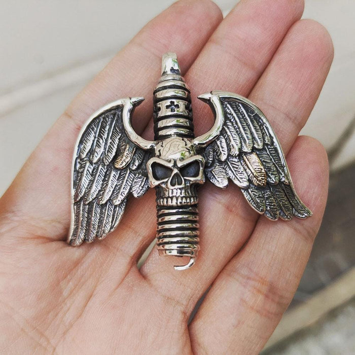 Resting in an open palm, the silver winged skull and spark plug pendant demonstrates its 58mm width and heavy cast design.