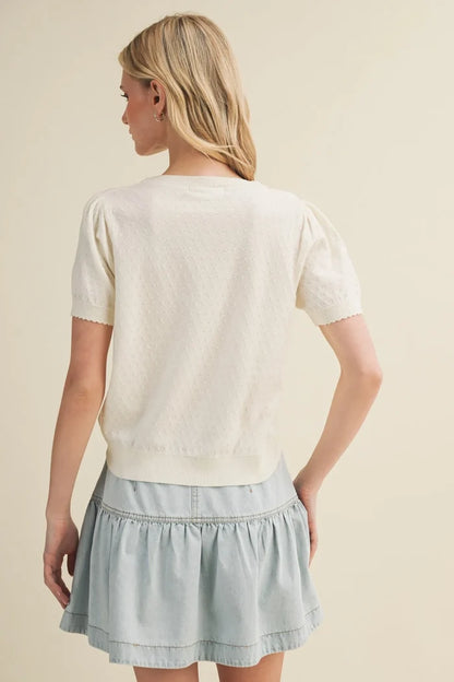 Cream-colored starburst pointelle puff sleeve top with short sleeves and textured knit pattern for stylish wear