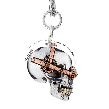 Side angle view of the steampunk skull pendant showing its 3D depth and detailed carvings on the silver.