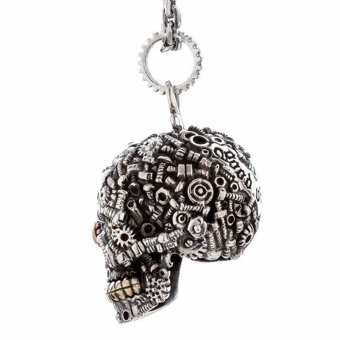 Close-up side view of a detailed sterling silver steampunk skull pendant with copper and brass accents, hanging against a white background