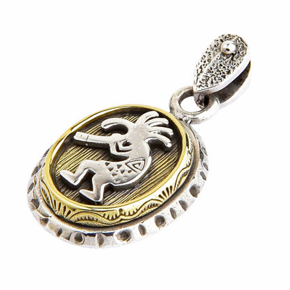 An angled view of the two-tone Kokopelli pendant in solid 925 sterling silver and brass.