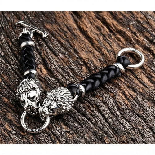Sterling silver lion head bracelet with black braided leather and T-bar clasp on wood background