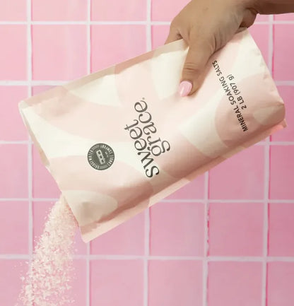 A pink and white patterned bag of sweet grace soaking salts labeled with black text for mineral soaking use