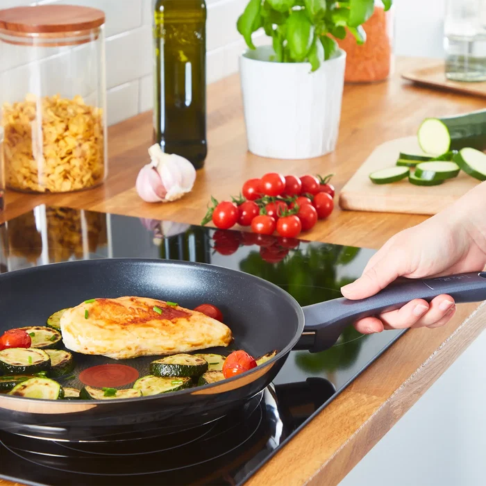 Tefal Daily Cook Induction Stainless Steel Frypan in use on induction cooktop