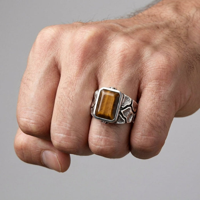 Tiger's Eye sterling silver men's ring worn on hand showing golden-brown gemstone and nature-inspired band design