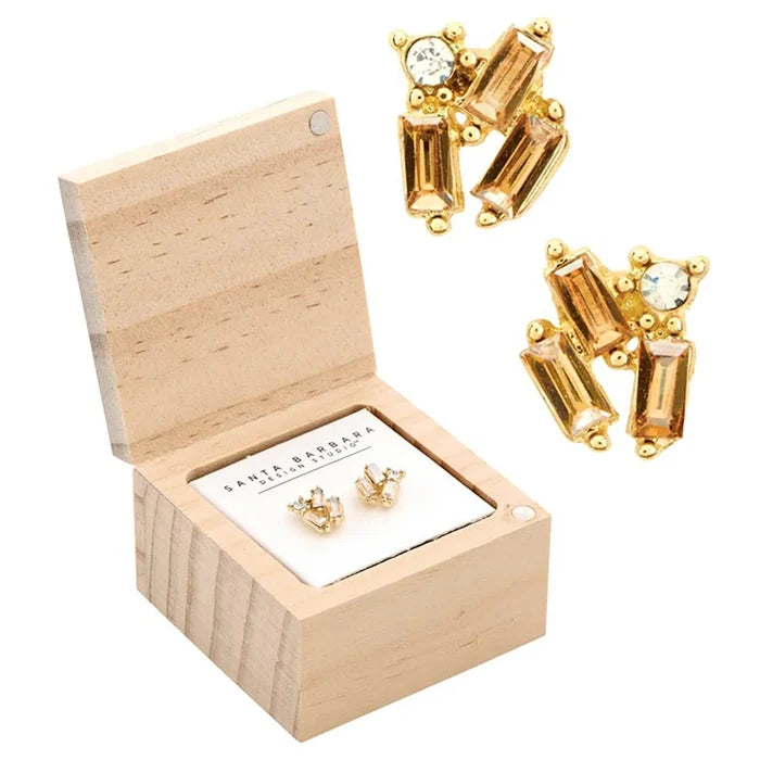 Gold-toned treasure box earrings with amber and clear stones in a wooden box