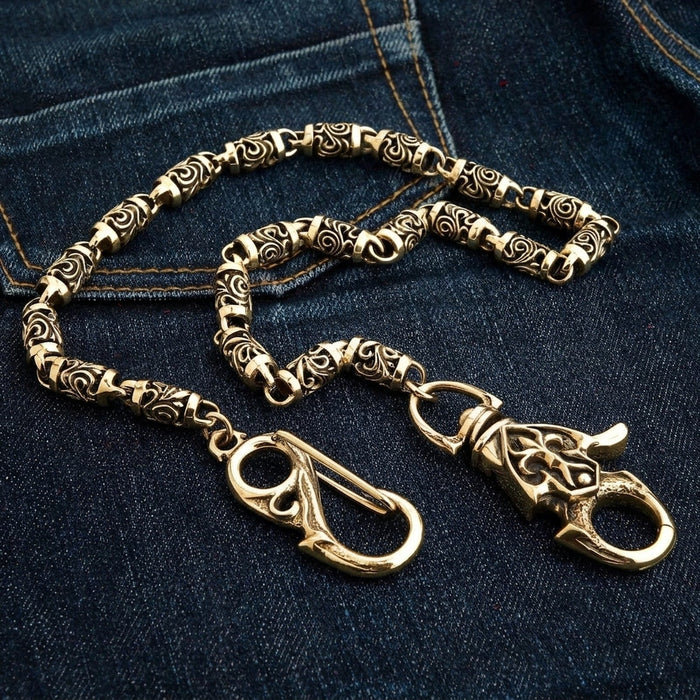 Both end clasps of the brass biker wallet chain side by side on dark denim - spring-gate hook and lobster claw.