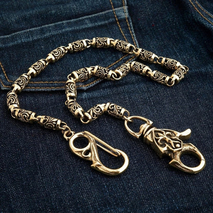Both end clasps of the brass biker wallet chain side by side on dark denim - spring-gate hook and lobster claw.