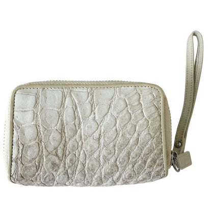 Close-up of the genuine crocodile hide texture and pearlescent finish on a white zip wallet with attached wristlet strap.