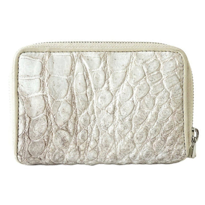 Rear exterior of the white zip wallet highlighting the large, distinct crocodile scales and continuous zipper track.