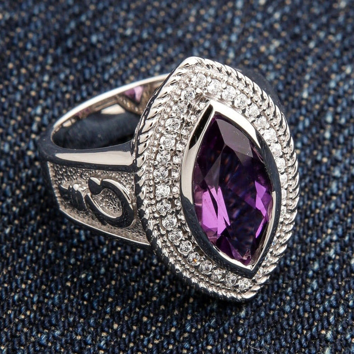 Close-up angled view of women's sterling silver bishop ring featuring marquise amethyst with pavé halo and crosier engraving